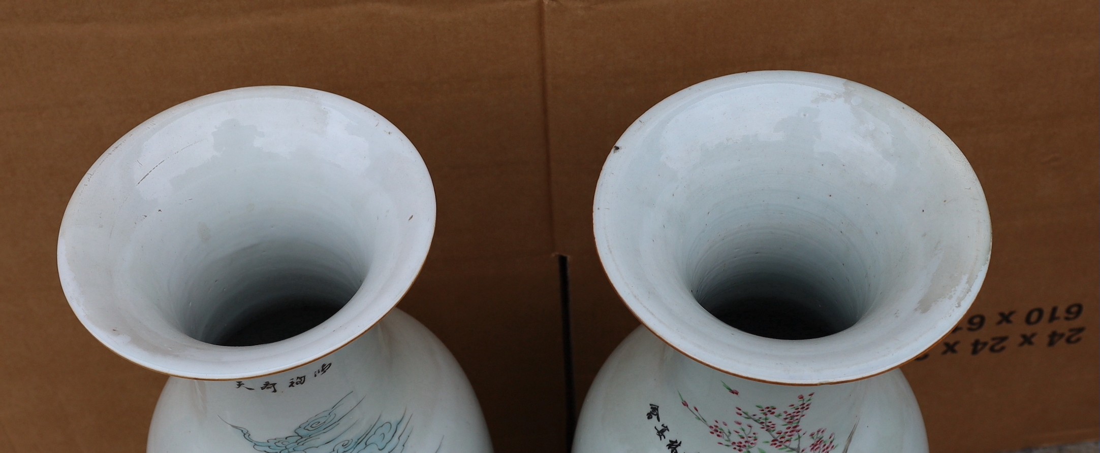 A pair of Japanese polychrome decorated porcelain baluster vases decorated with figures in gardens, height 57cm